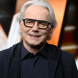 Uśmiechnięty Robert Janowski w okularach, gotowy do zagrania w "Jaka to melodia?".